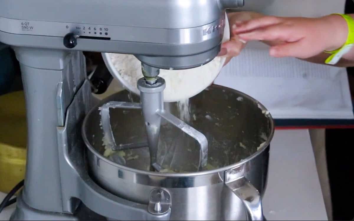 Kristin and Kat are adding crumb cake to the mixing bowl