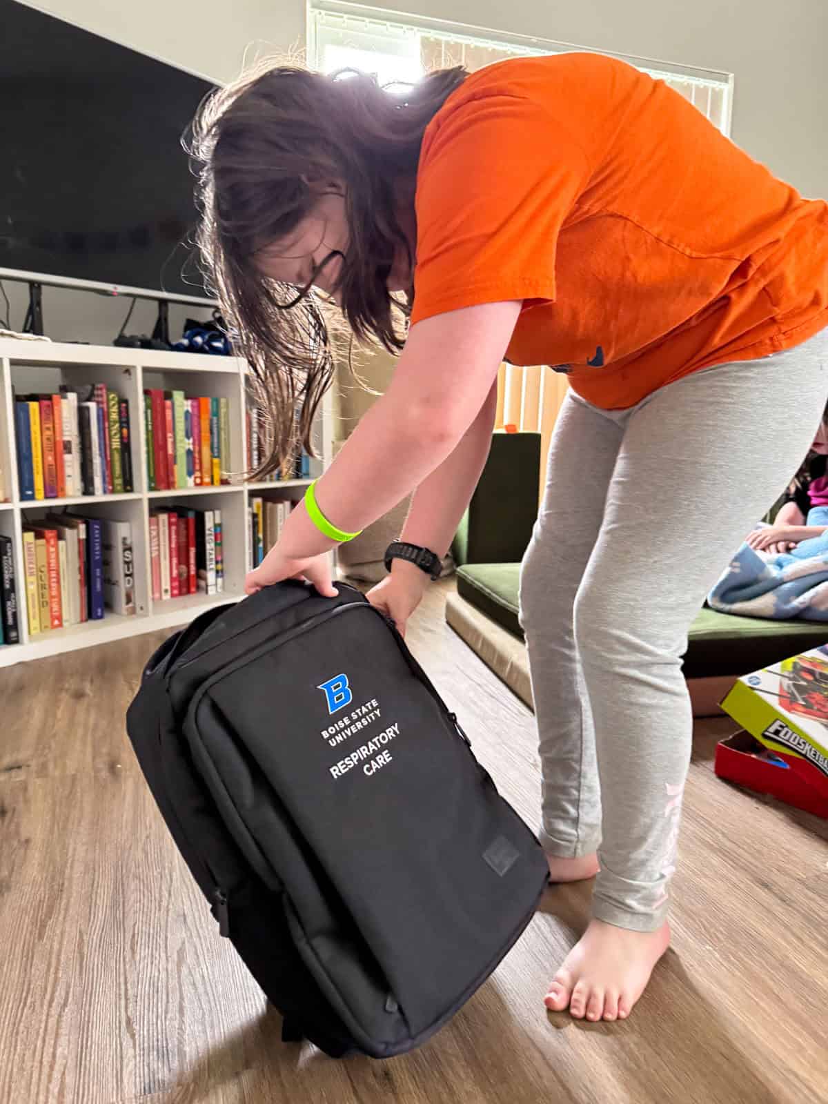 Kaia is opening her Boise State respiratory care bag from her grandpa