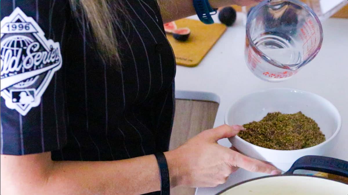 Kristin is adding water to a black masala spice blend