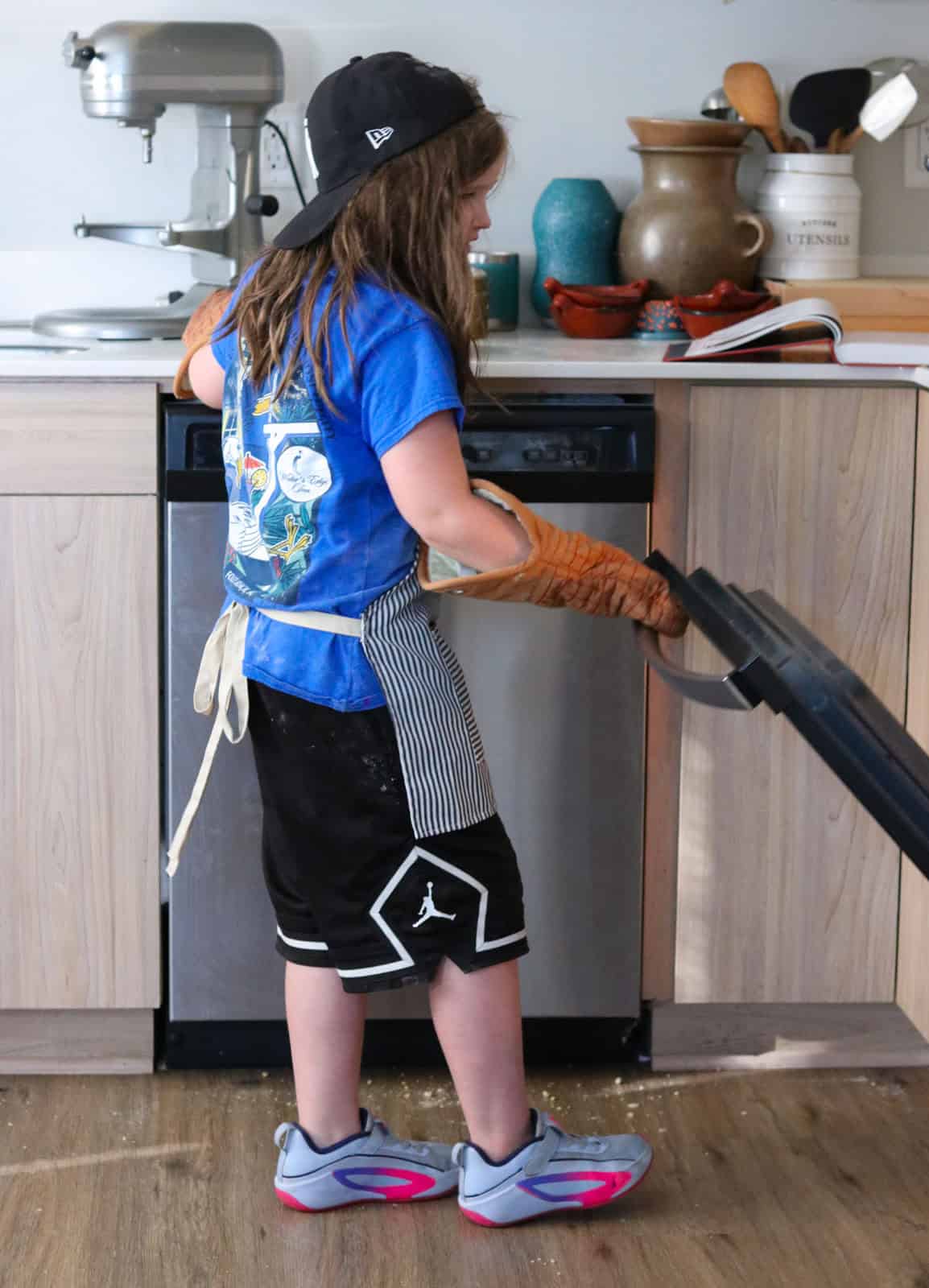 Kat is opening the oven door
