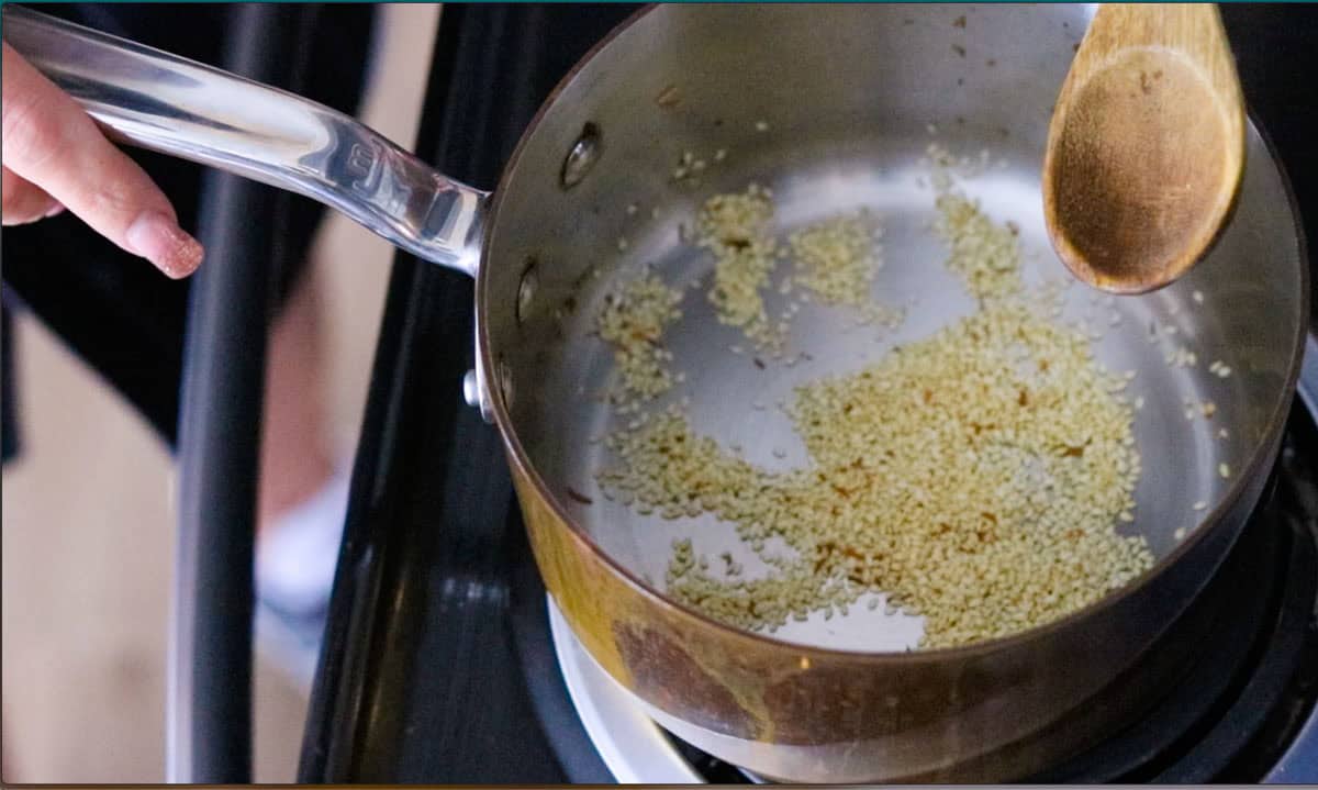 white sesame seeds roasting in a saucepan