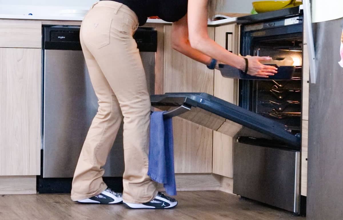 Kristin is transferring a baking dish to the oven