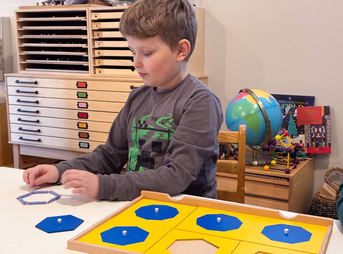 Noah is forming a hexagon from a Montessori bead chain