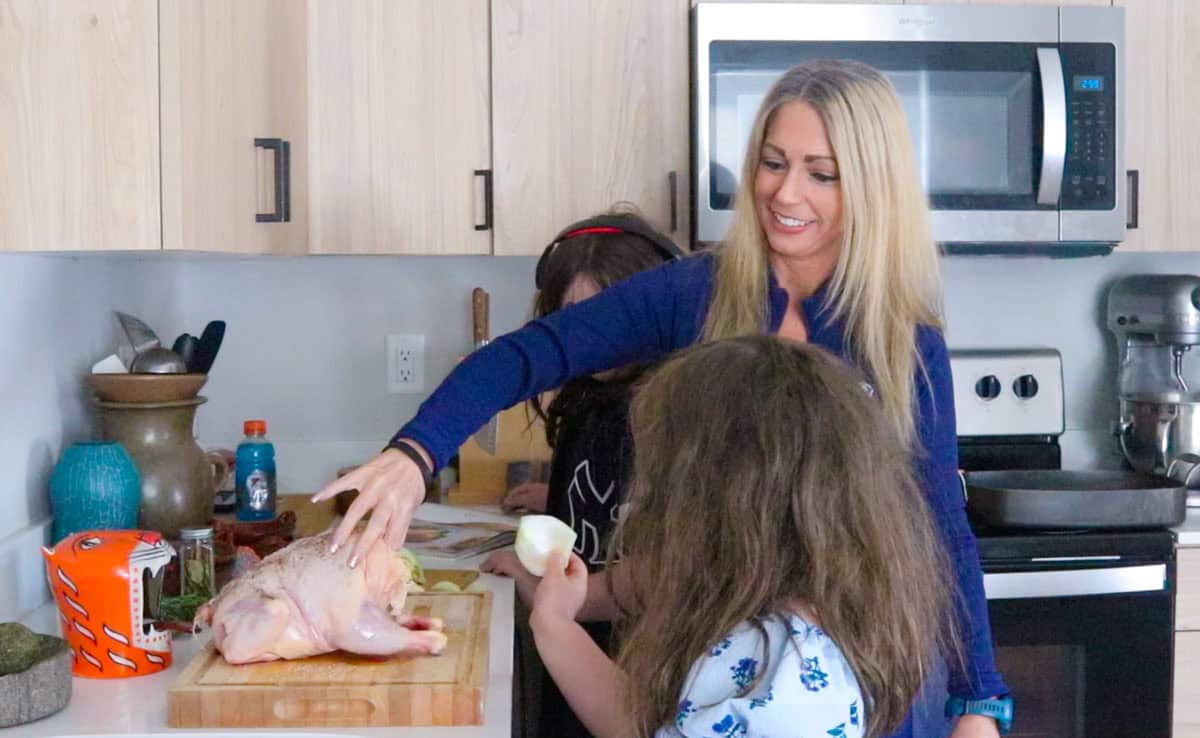 Kat is attempting to throw the onion into the chicken