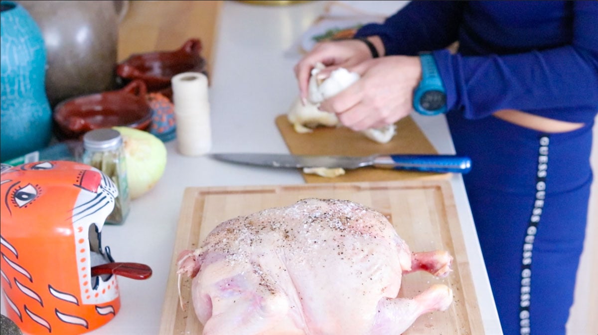 season whole chicken and halved garlic