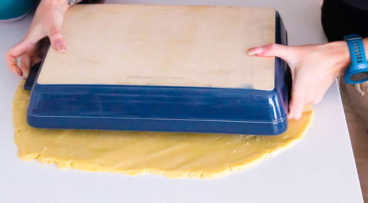 Kristin is measuring the dough to the baking dish