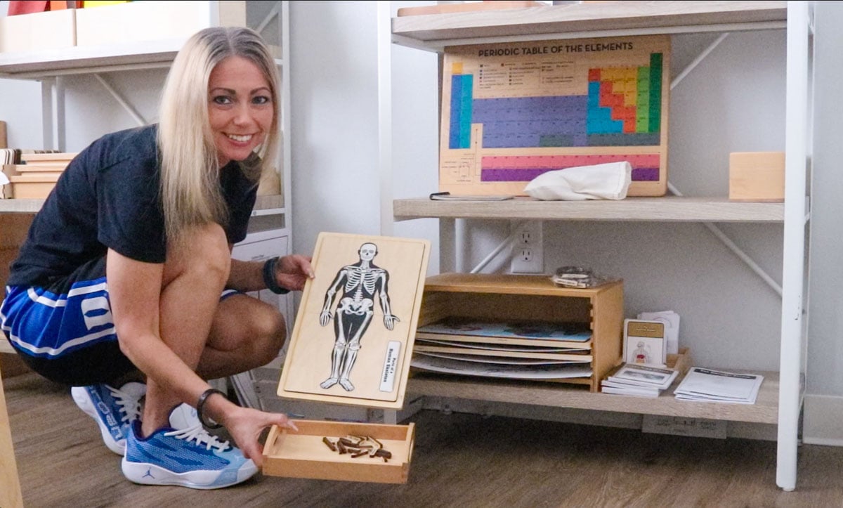 Kristin is holding the skeletal system puzzle and the labels