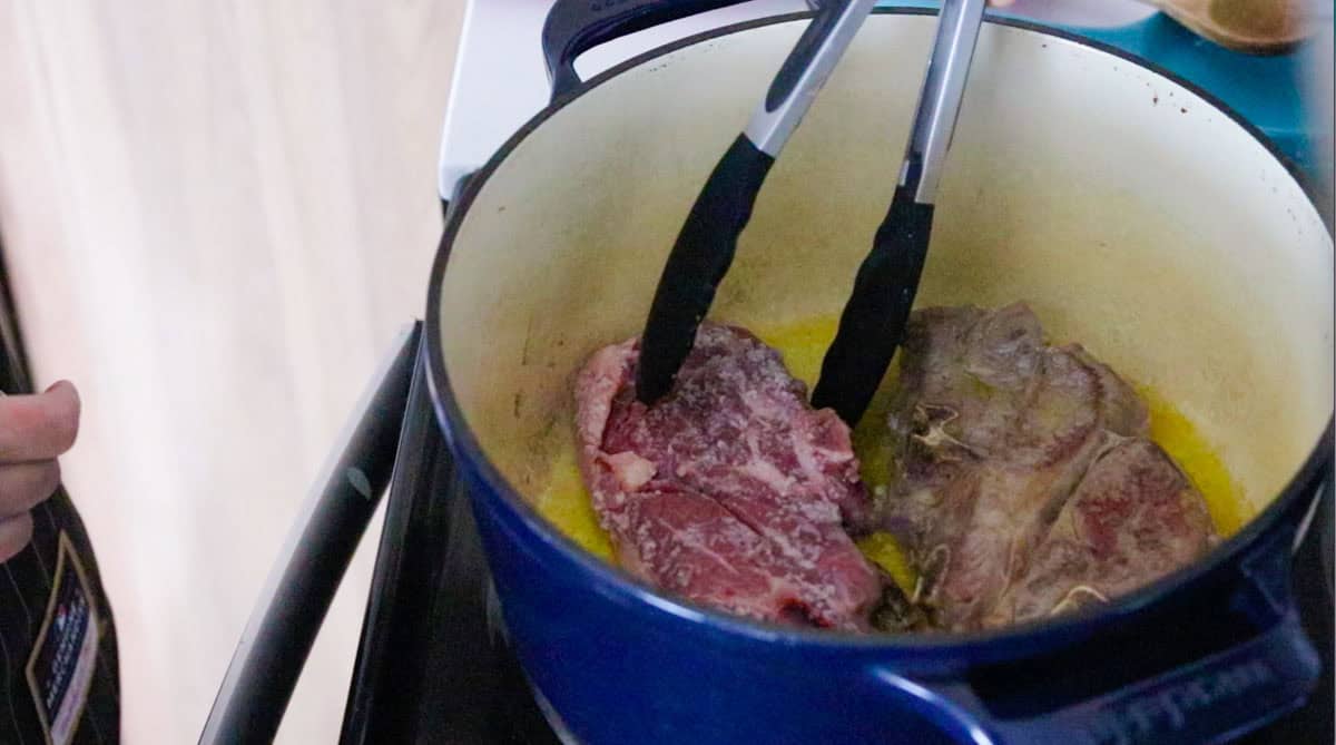turning the lamb shoulder with tongs