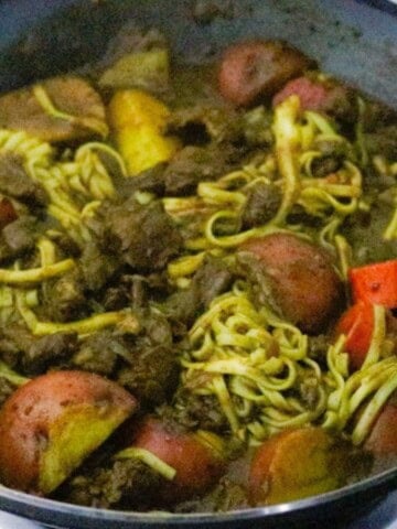 curry goat lo mein in a wok