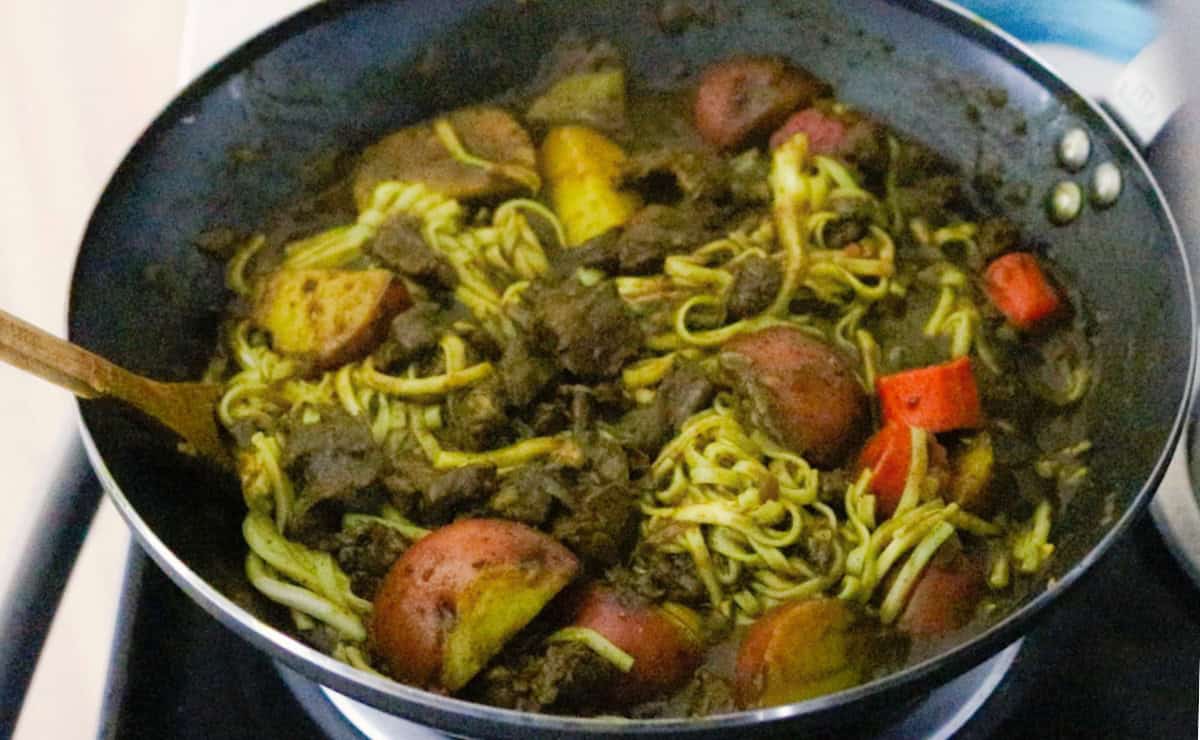 curry goat lo mein in a wok