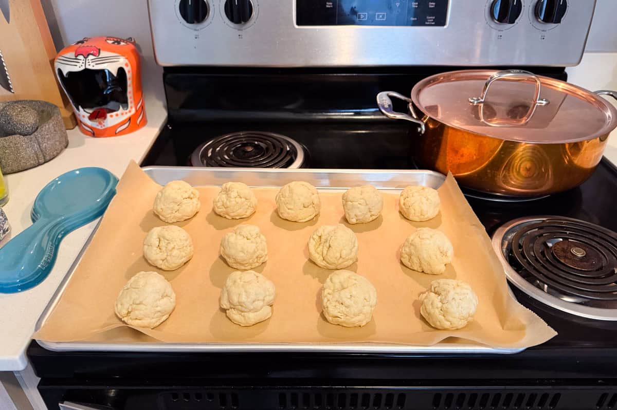 unbaked drop biscuits on a baking sheet with parchment paper