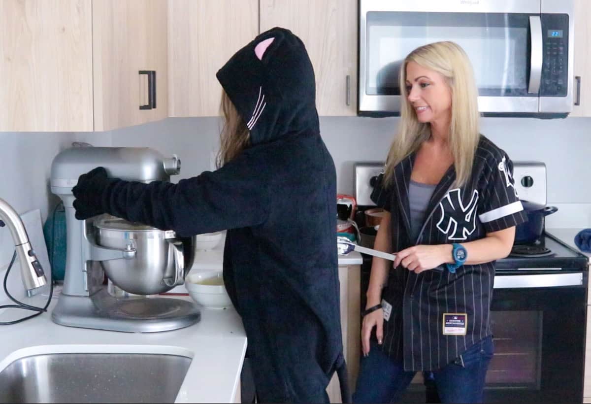 Kat is running the mixer to make the cheesecake