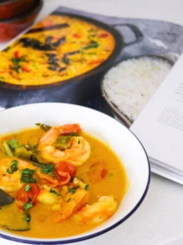 okra and shrimp coconut curry in a bowl beside Veg-Table cookbook
