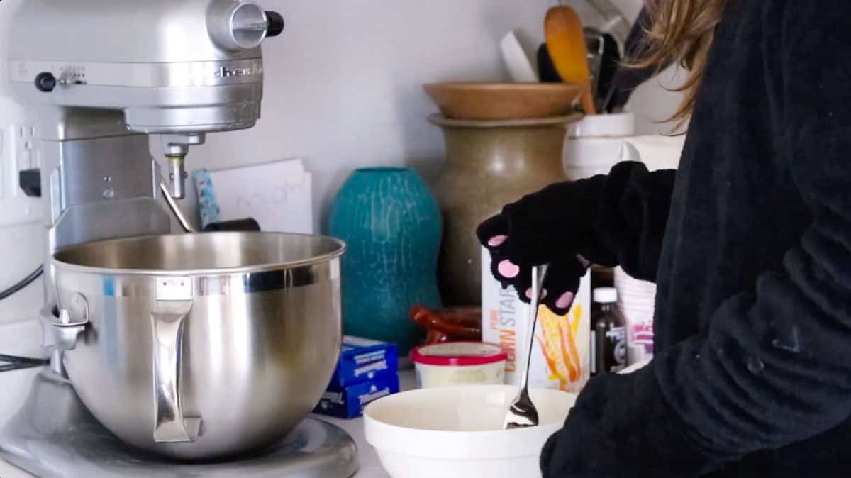 Kat is whisking eggs with a fork